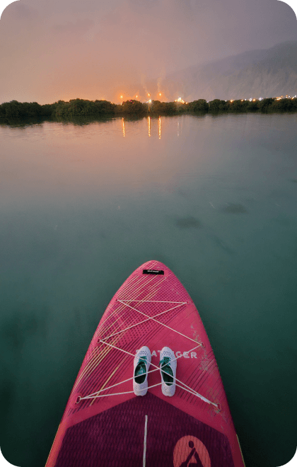 Paddleboarding on calm water at dusk